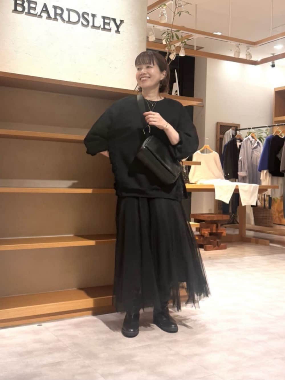 ブラック系のTシャツ/カットソー、ブラック系のスカートを着用したレディースの秋コーディネートの5枚目の写真