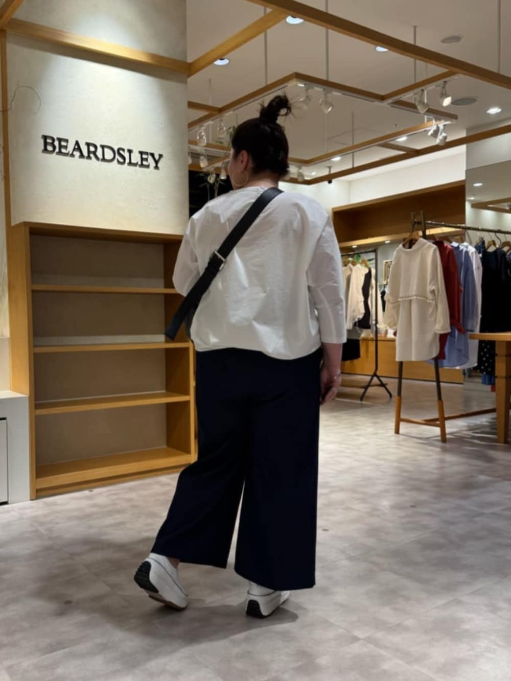 ブルー系のその他パンツ、ブラック系のショルダーバッグ、ホワイト系のシャツ/ブラウスを着用したレディースの春コーディネートの3枚目の写真