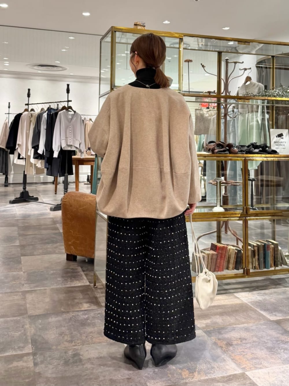 ブラック系のその他パンツ、ベージュ系のノーカラーコートを着用したレディースの冬コーディネートの3枚目の写真