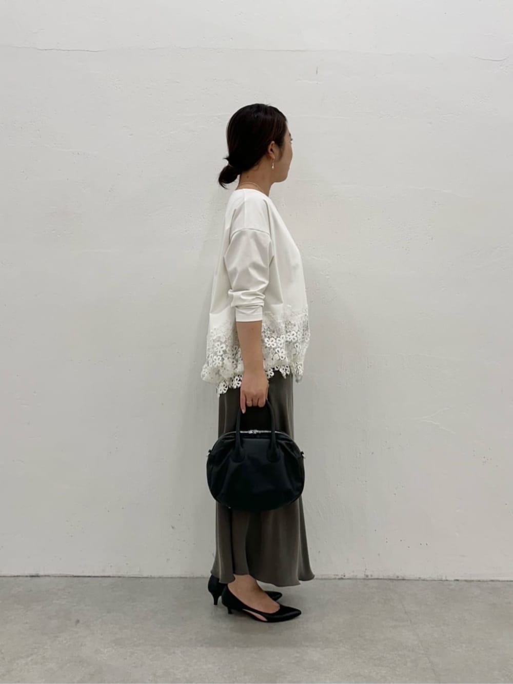 グリーン系のスカート、ホワイト系のTシャツ/カットソーを着用したレディースの冬コーディネートの2枚目の写真