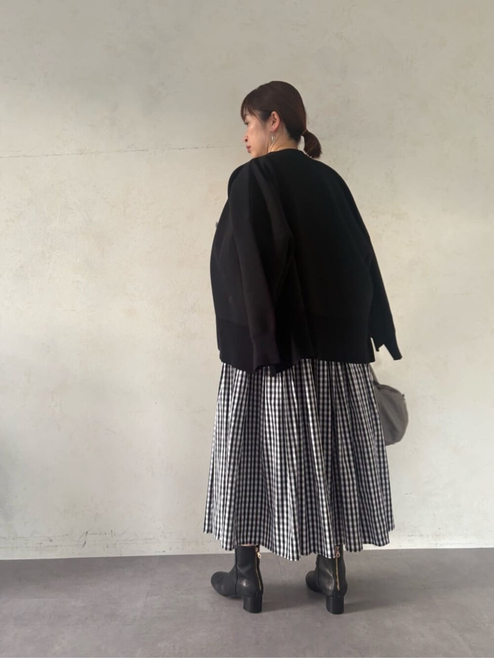 グレー系のボストンバッグ、ブラック系のカーディガン/ボレロ、ブラック系のワンピースを着用したレディースの冬コーディネートの4枚目の写真