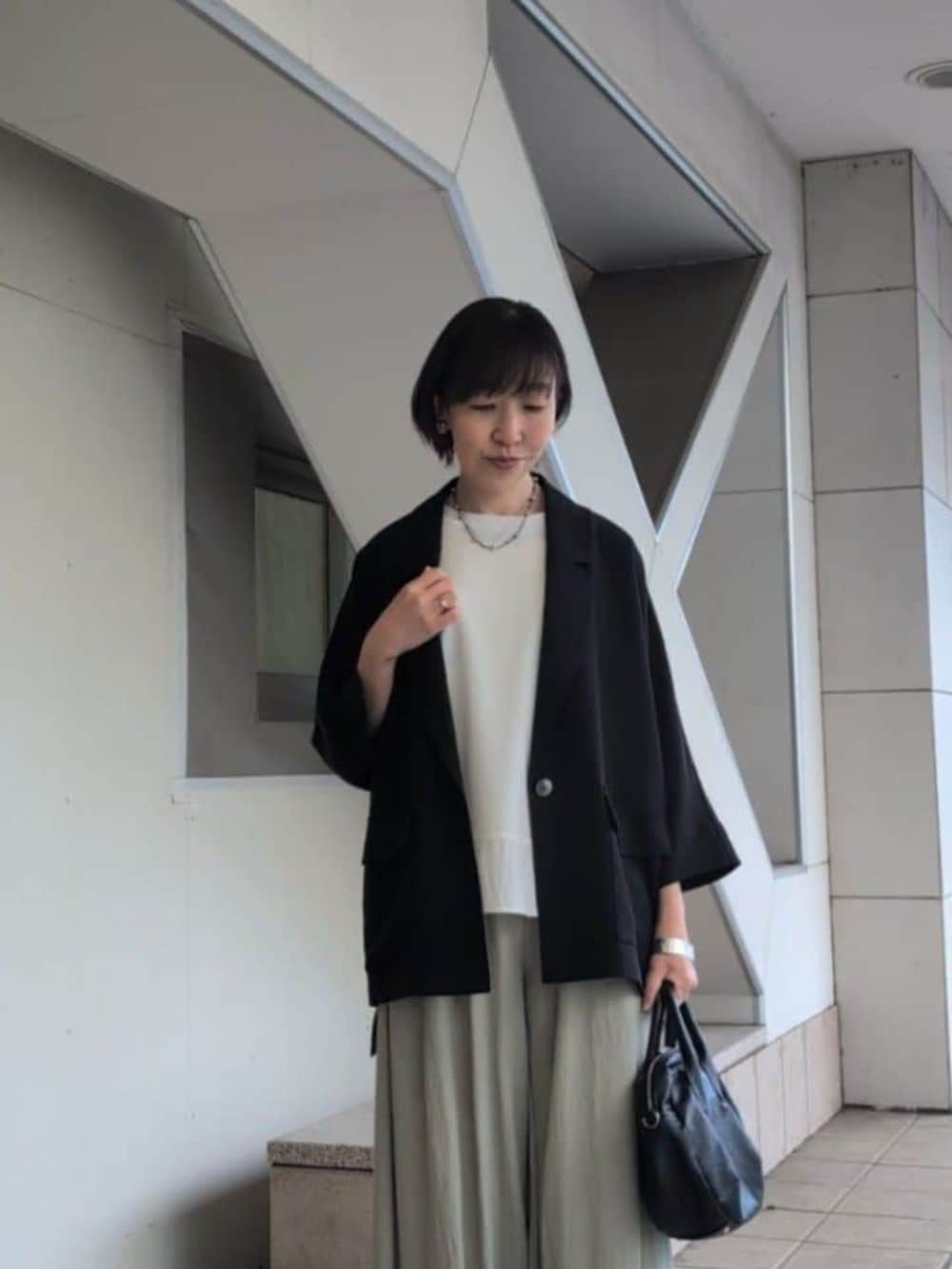 ブラック系のボストンバッグ、グリーン系のその他パンツ、ホワイト系のTシャツ/カットソーを着用したレディースの春コーディネートの4枚目の写真