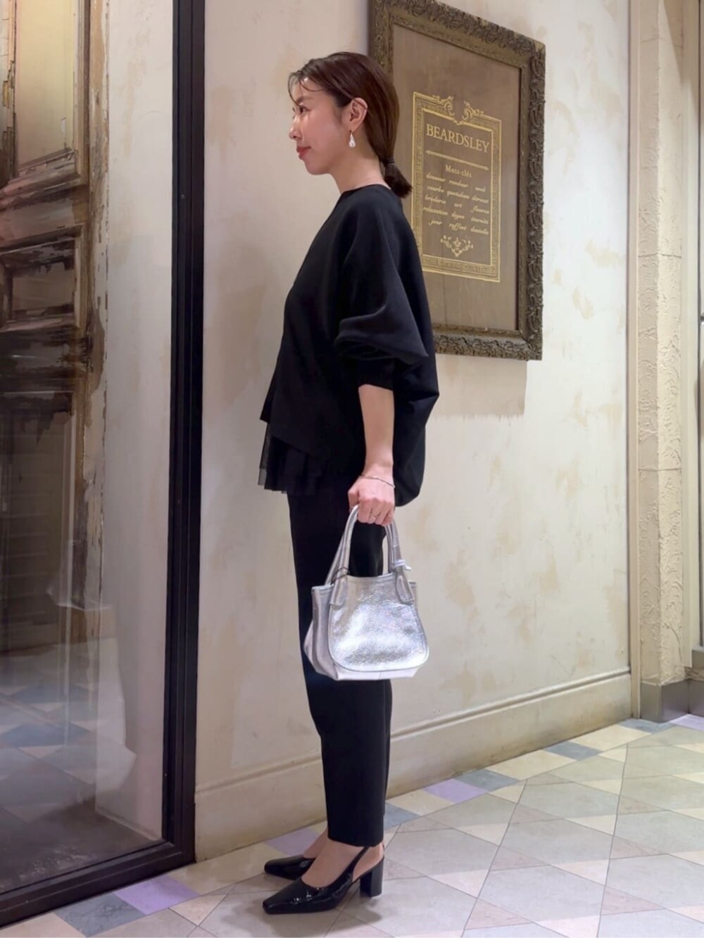 ブラック系のカーディガン/ボレロ、ブラック系のその他パンツ、シルバー系のトートバッグを着用したレディースの冬コーディネートの2枚目の写真