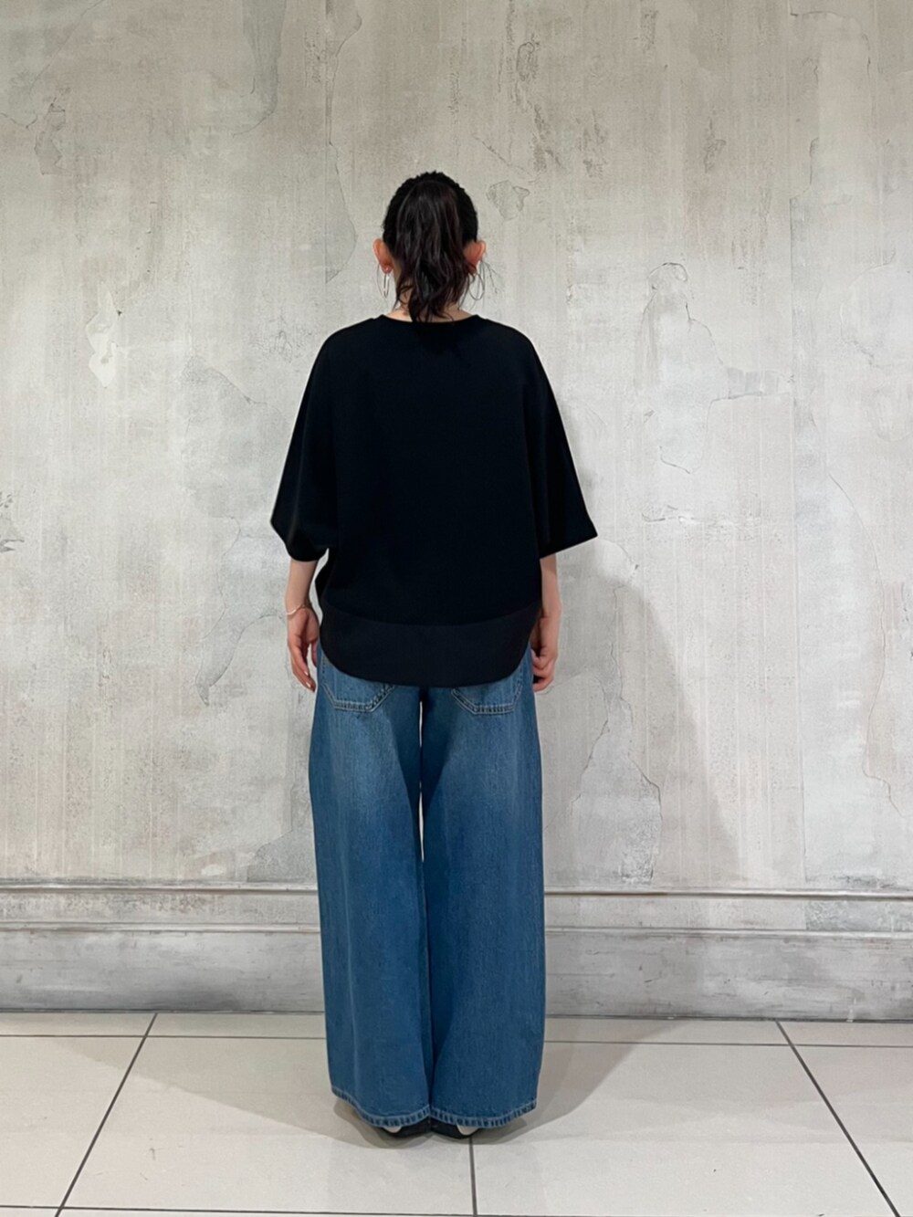 ブルー系のその他パンツ、ブラック系のTシャツ/カットソー、ホワイト系のスニーカーを着用したレディースの春コーディネートの7枚目の写真