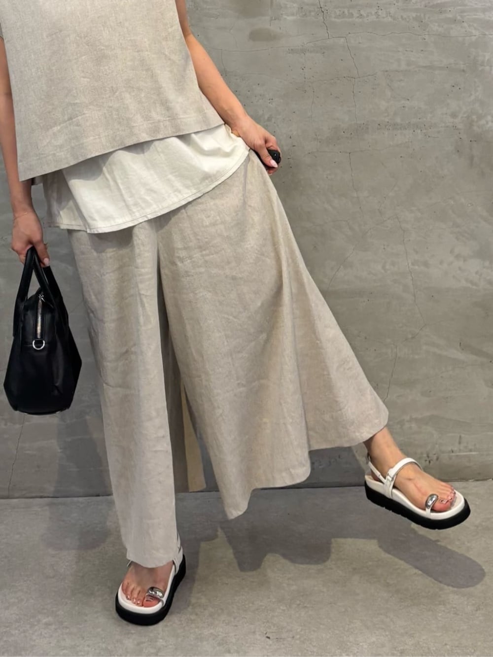 ブラック系のボストンバッグ、ホワイト系のサンダル、ホワイト系のシャツ/ブラウスを着用したレディースの春コーディネートの8枚目の写真