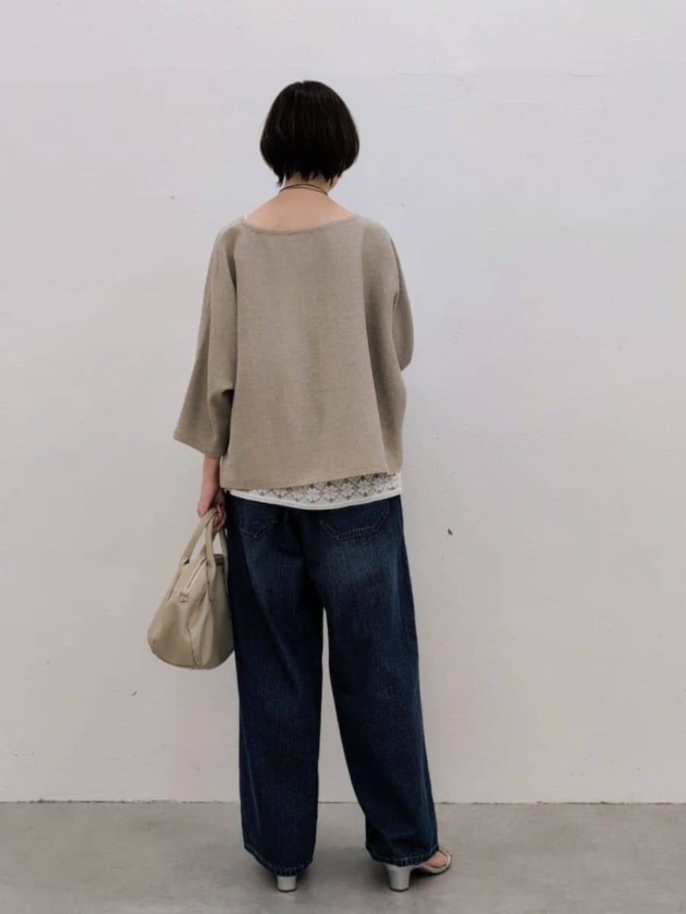 グレー系のボストンバッグ、ホワイト系のシャツ/ブラウス、ベージュ系のニット/セーターを着用したレディースの春コーディネートの4枚目の写真