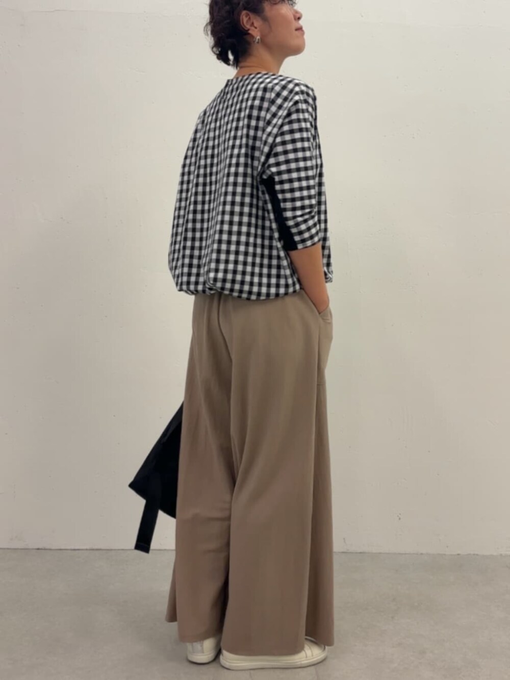 ブラック系のシャツ/ブラウス、ベージュ系のその他パンツ、ブラック系のショルダーバッグを着用したレディースの冬コーディネートの5枚目の写真