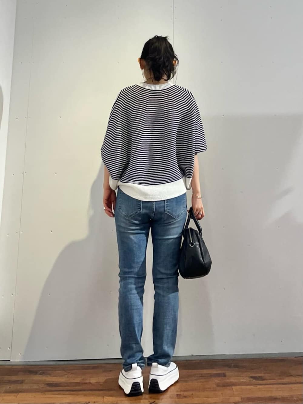 ブルー系のデニムパンツ、ブルー系のニット/セーターを着用したレディースの春コーディネートの5枚目の写真