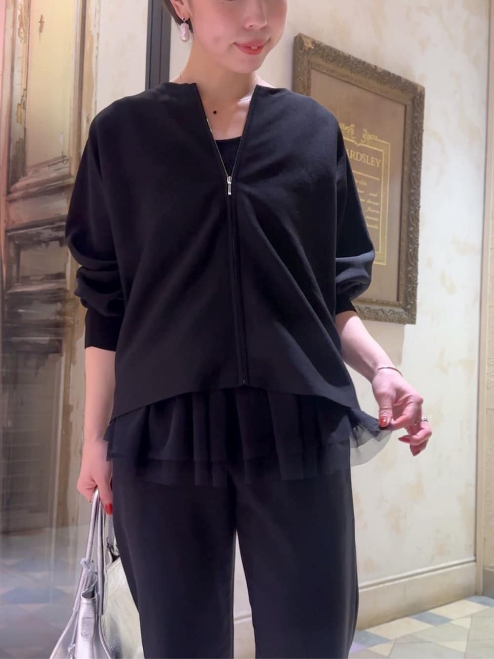 ブラック系のカーディガン/ボレロ、ブラック系のその他パンツ、シルバー系のトートバッグを着用したレディースの冬コーディネートの5枚目の写真