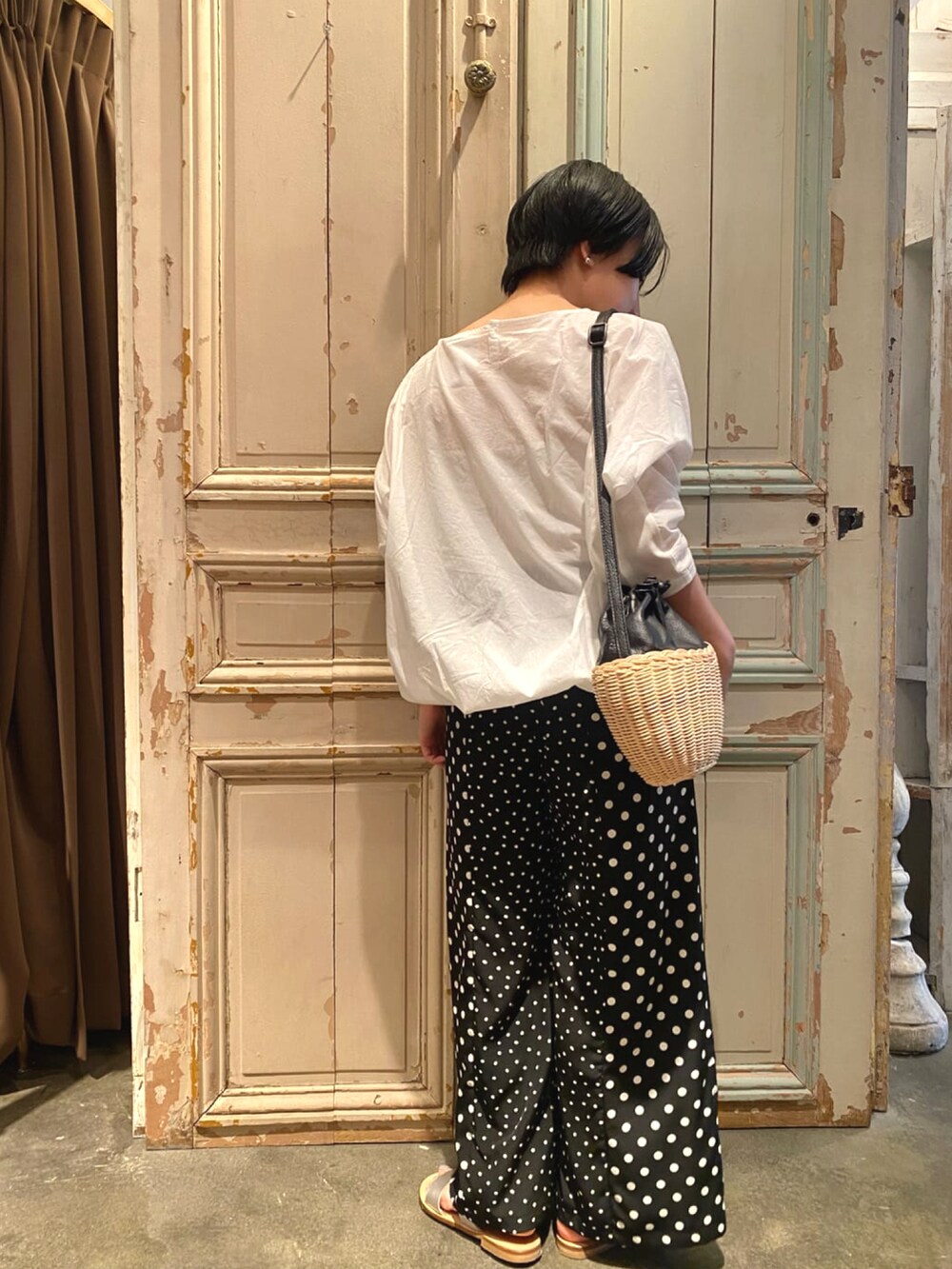 ブラック系のその他パンツ、ホワイト系のシャツ/ブラウス、シルバー系のサンダルを着用したレディースの春コーディネートの3枚目の写真