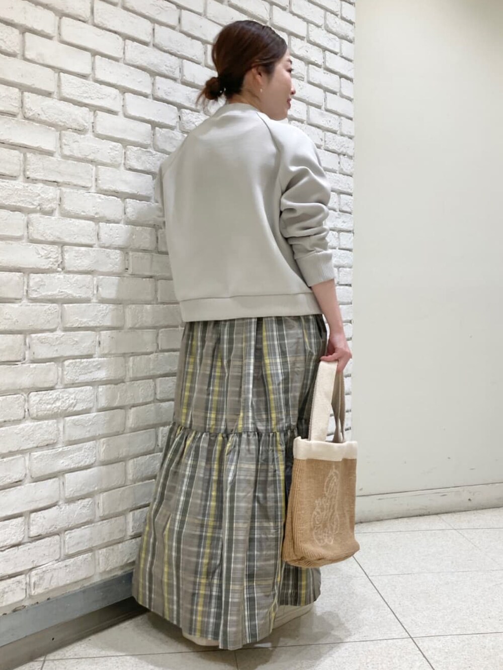 グレー系のブルゾン、グレー系のスカートを着用したレディースの冬コーディネートの3枚目の写真