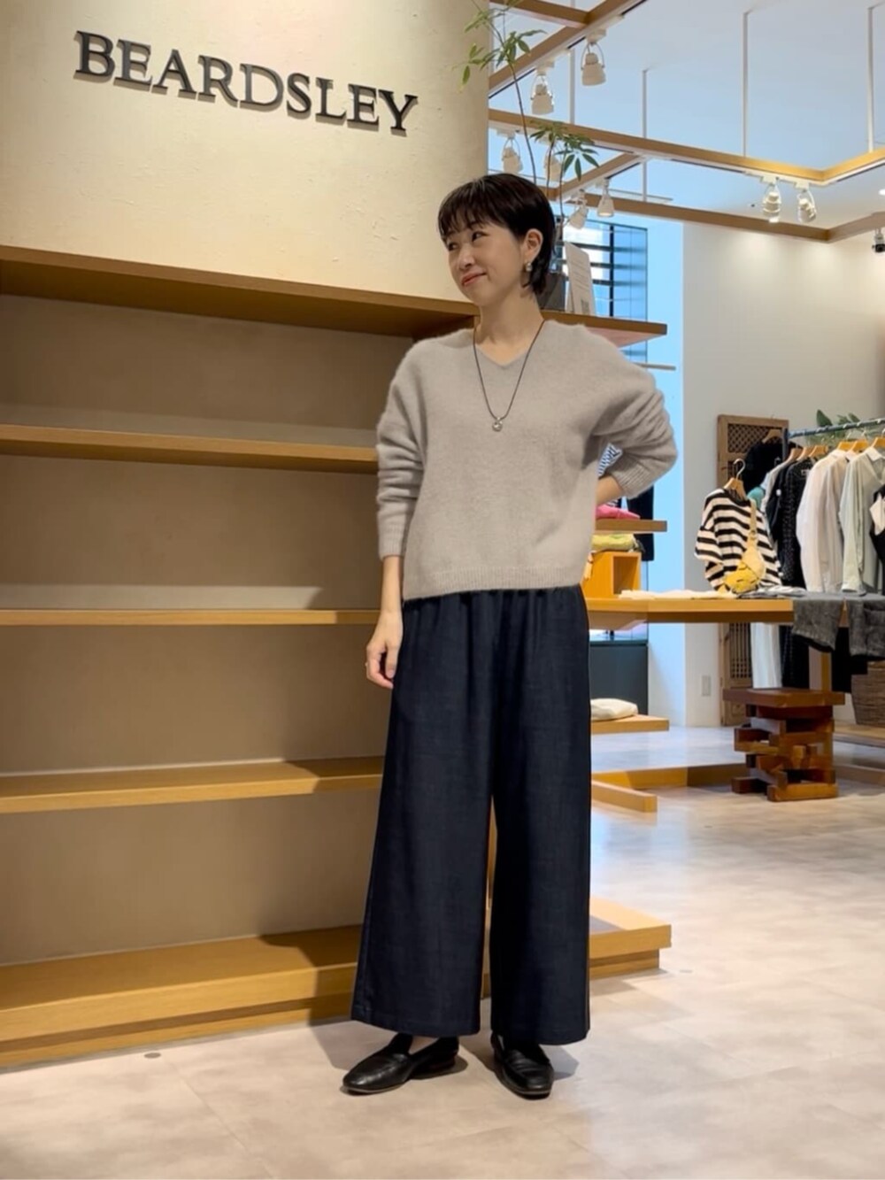 ブルー系のその他パンツ、グレー系のニット/セーター、ブラック系のダウンジャケット/コートを着用したレディースの冬コーディネートの8枚目の写真