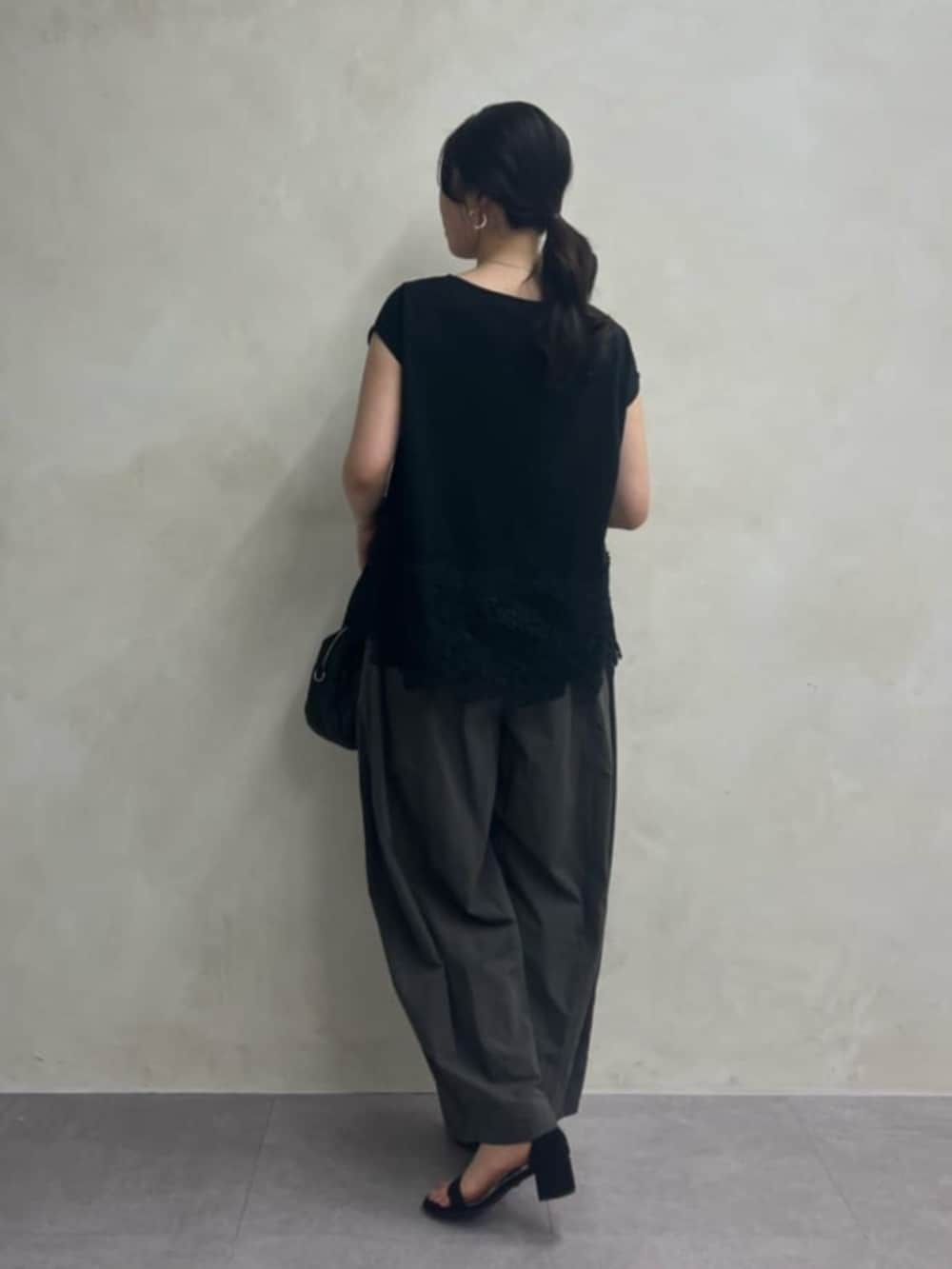 ブラック系のボストンバッグ、グレー系のその他パンツ、ブラック系のTシャツ/カットソーを着用したレディースの冬コーディネートの4枚目の写真