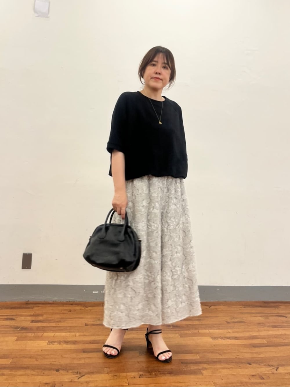グレー系のボストンバッグ、ホワイト系のその他パンツ、ブラック系のTシャツ/カットソーを着用したレディースの夏コーディネートの2枚目の写真