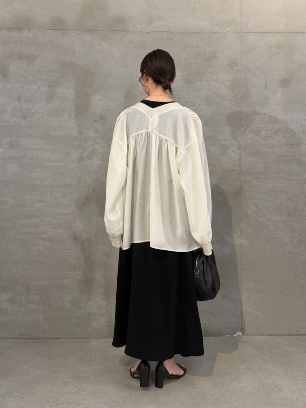 ブラック系のボストンバッグ、ホワイト系のシャツ/ブラウス、ブラック系のワンピースを着用したレディースの春コーディネートの4枚目の写真