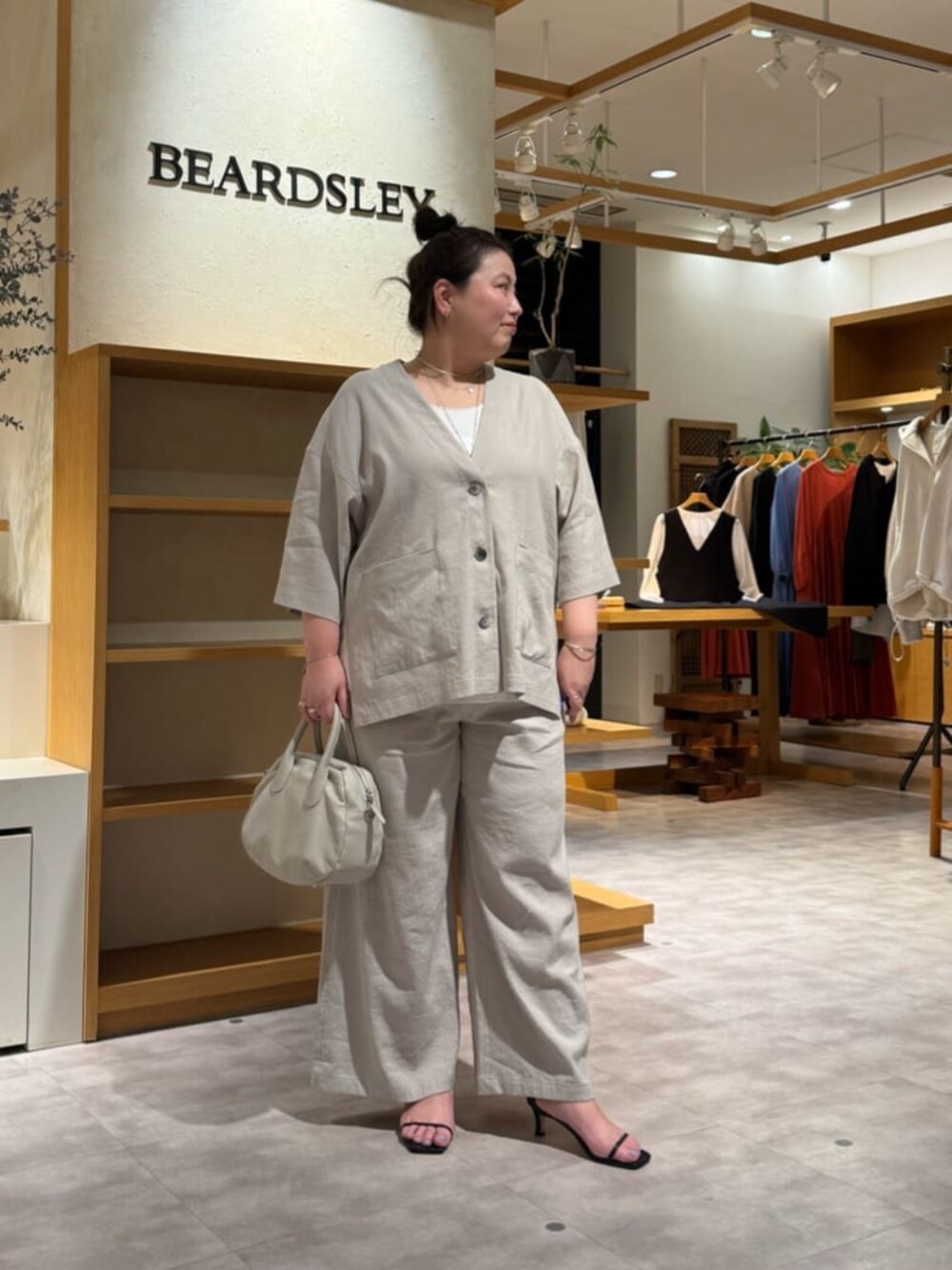 グレー系のボストンバッグ、ホワイト系のシャツ/ブラウス、グレー系のその他パンツを着用したレディースの春コーディネートの5枚目の写真