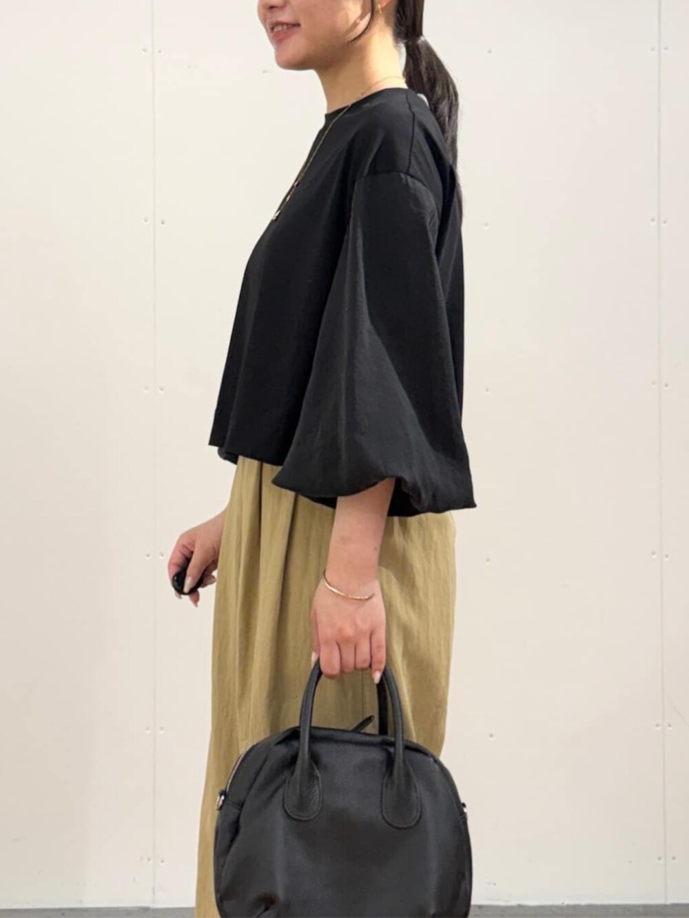 イエロー系のその他パンツ、ブラック系のTシャツ/カットソーを着用したレディースの夏コーディネートの5枚目の写真