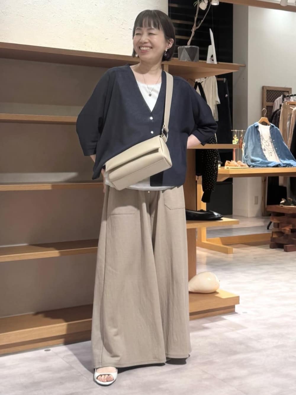 ベージュ系のその他パンツ、ベージュ系のショルダーバッグ、ブルー系のカーディガン/ボレロを着用したレディースの夏コーディネートの2枚目の写真