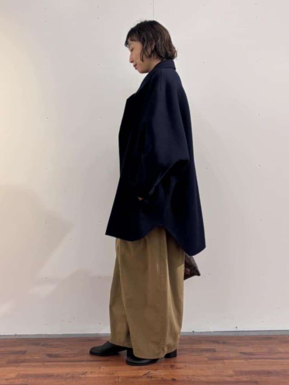 イエロー系のその他パンツ、ブラック系のニット/セーター、ブラック系のブーツを着用したレディースの秋コーディネートの4枚目の写真