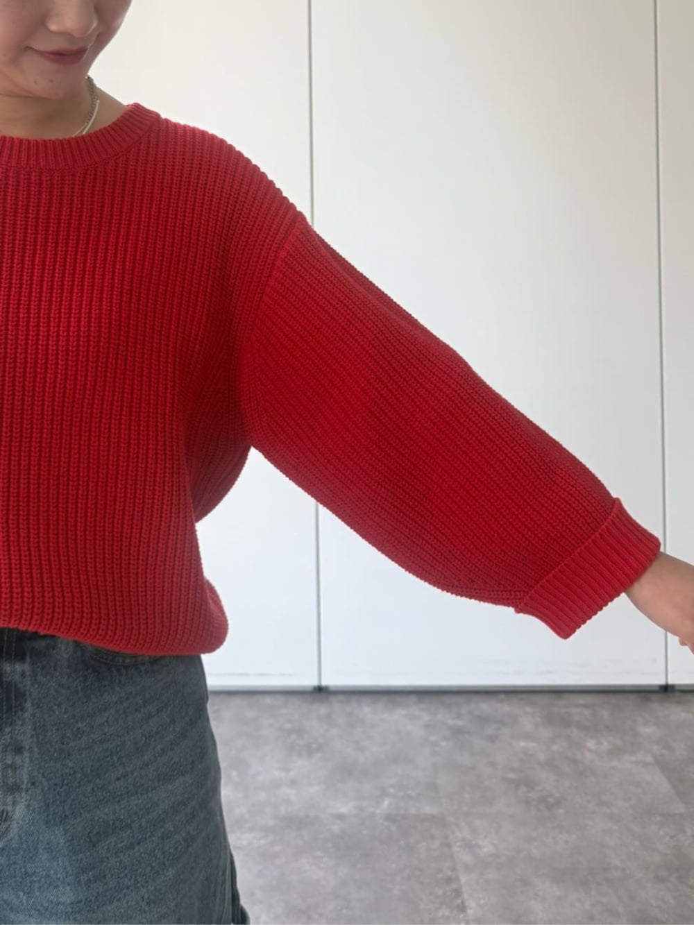 レッド系のニット/セーター、グレー系のトートバッグを着用したレディースの冬コーディネートの8枚目の写真