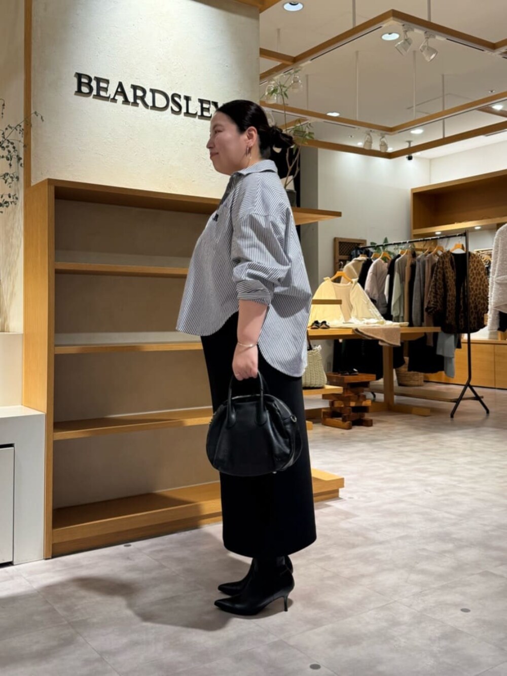 ブラック系のブーツ、ブルー系のシャツ/ブラウスを着用したレディースの冬コーディネートの4枚目の写真