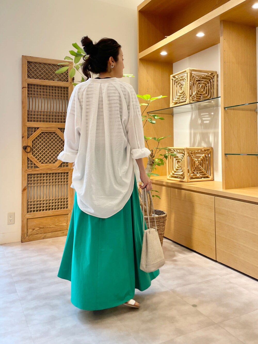 グリーン系のスカート、ホワイト系のシャツ/ブラウス、ホワイト系のTシャツ/カットソーを着用したレディースの夏コーディネートの3枚目の写真