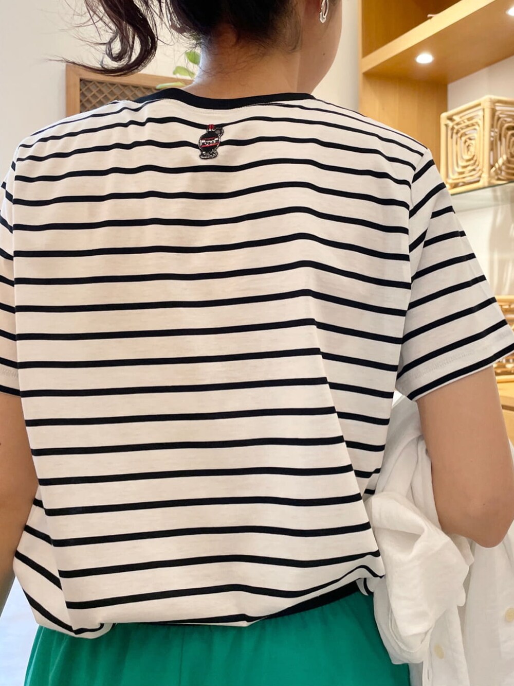 グリーン系のスカート、ホワイト系のシャツ/ブラウス、ホワイト系のTシャツ/カットソーを着用したレディースの夏コーディネートの4枚目の写真