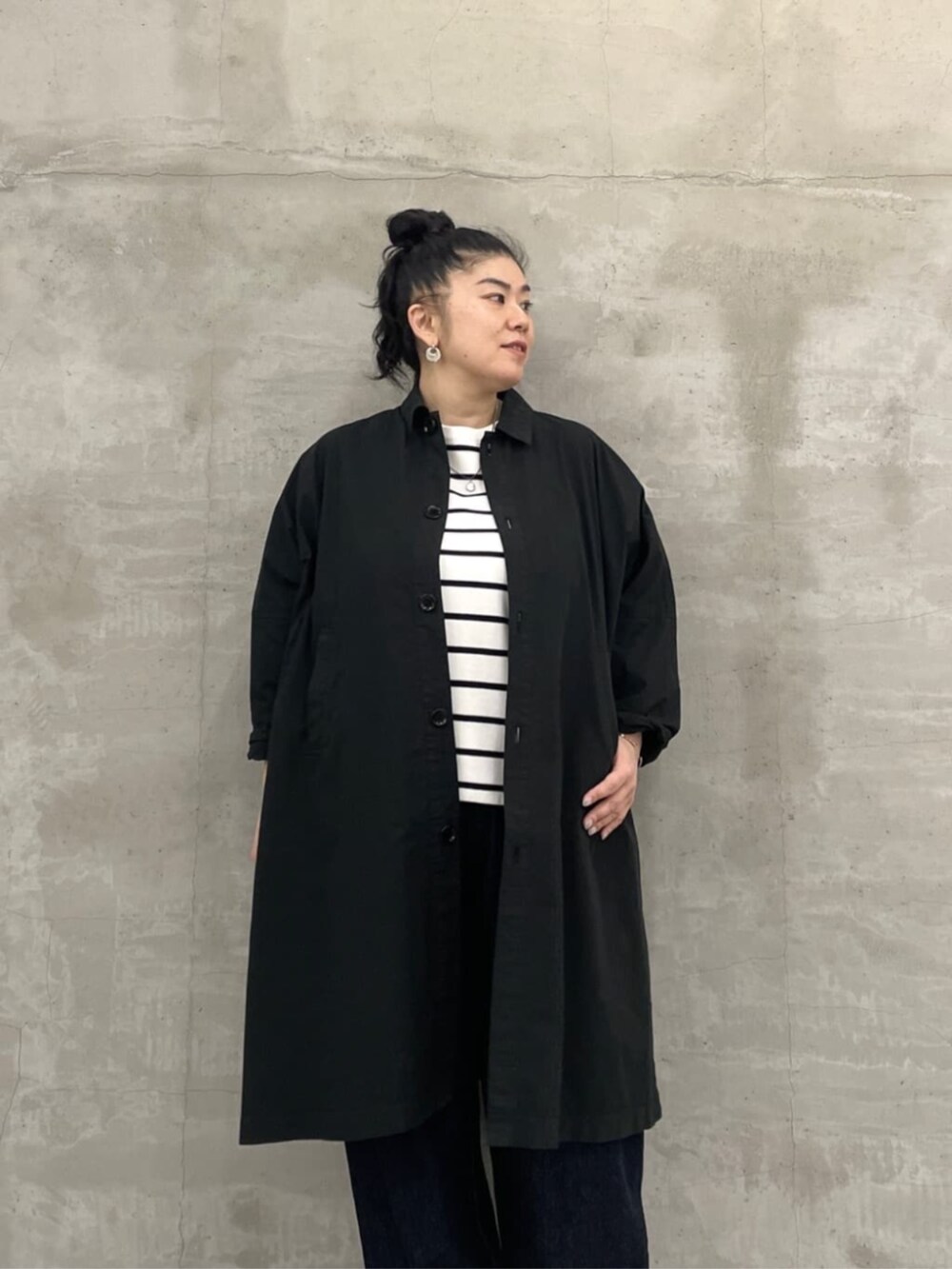 ホワイト系のトートバッグ、ブルー系のデニムパンツ、ブラック系のその他アウターを着用したレディースの冬コーディネートの5枚目の写真