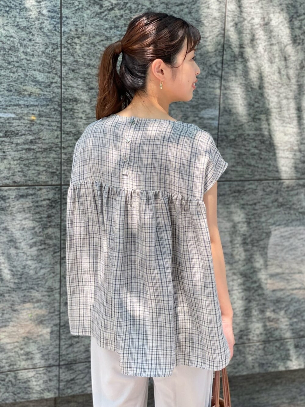 ブルー系のシャツ/ブラウス、グレー系のその他パンツ、ピンク系のかごバッグを着用したレディースの夏コーディネートの2枚目の写真