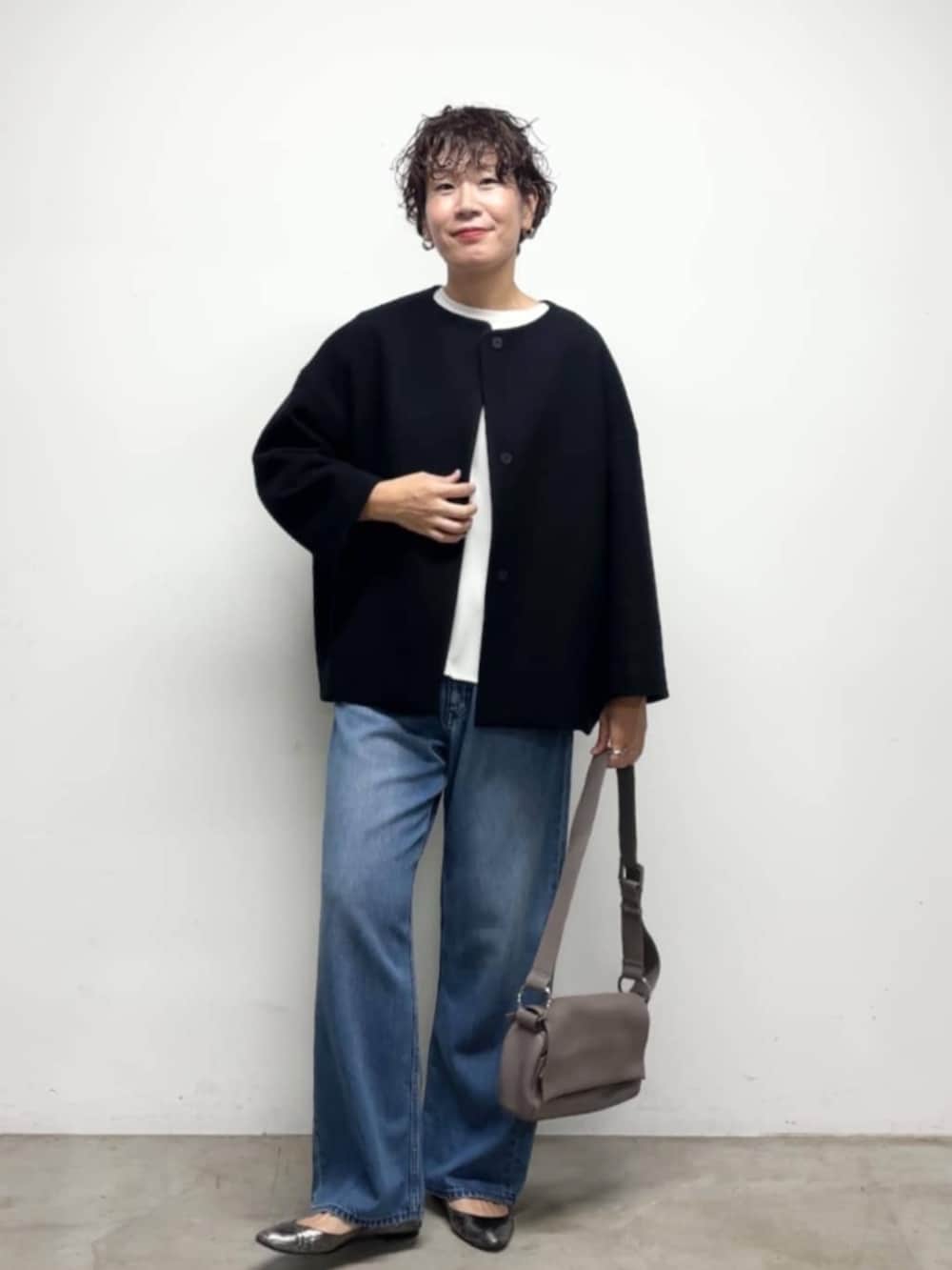 ブルー系のデニムパンツ、ブルー系のノーカラーコート、ホワイト系のシャツ/ブラウスを着用したレディースの冬コーディネートの8枚目の写真