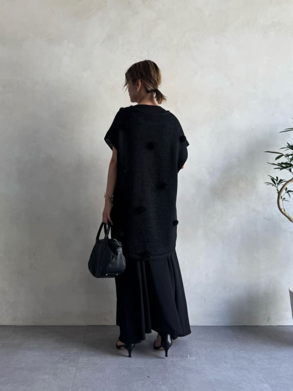 ブラック系のニット/セーターを着用したレディースの冬コーディネートの2枚目の写真