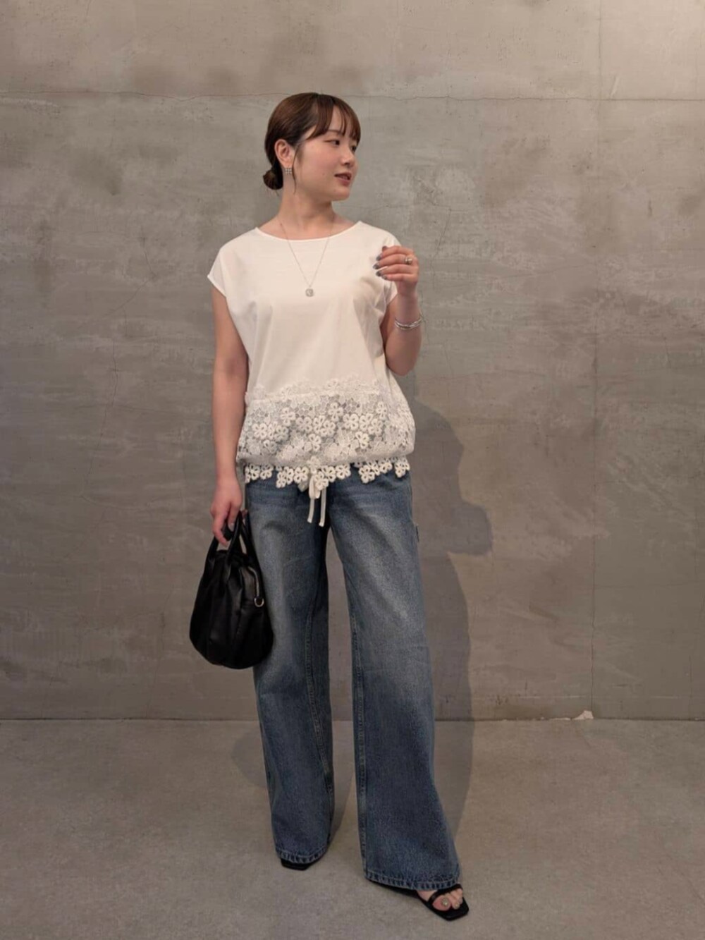 ブラック系のボストンバッグ、ブルー系のその他パンツ、ホワイト系のTシャツ/カットソーを着用したレディースの春コーディネートの7枚目の写真