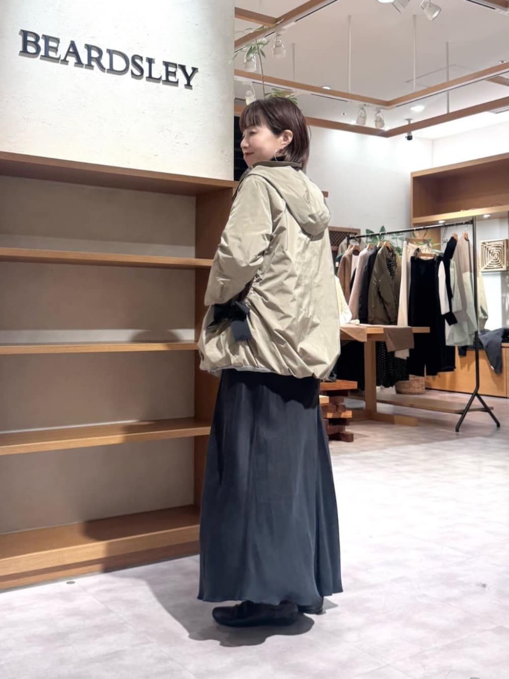 ブラック系のスカート、ブラウン系のブルゾンを着用したレディースの冬コーディネートの2枚目の写真