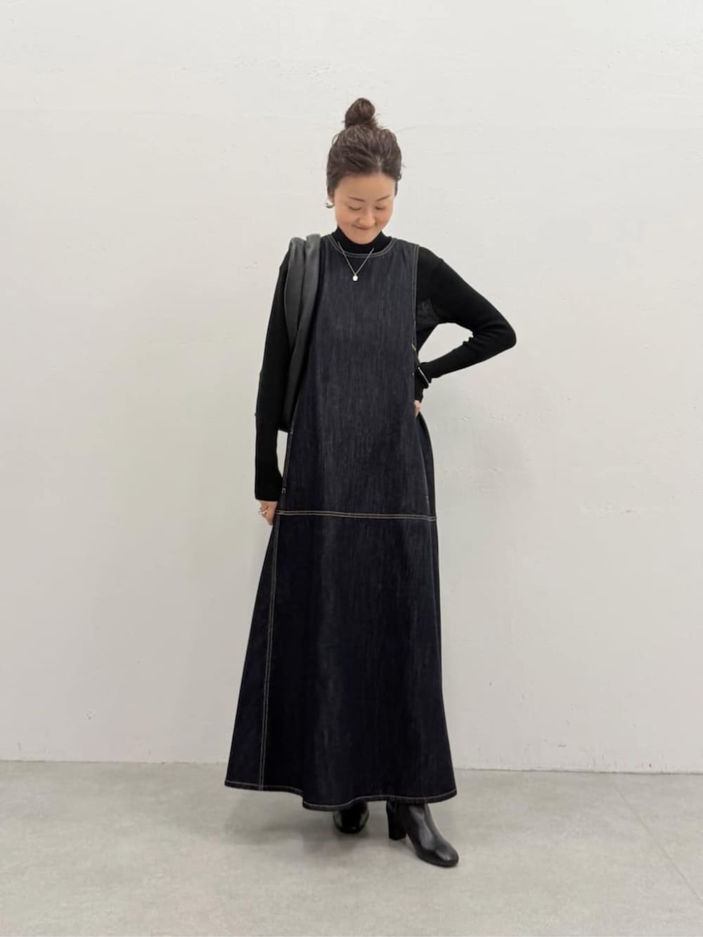 ブラック系のニット/セーター、ブルー系のワンピース、ブラック系のトートバッグを着用したレディースの夏コーディネートの4枚目の写真