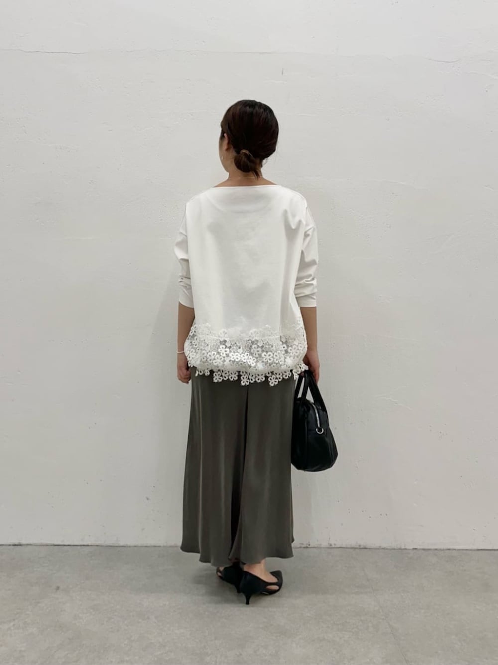 グリーン系のスカート、ホワイト系のTシャツ/カットソーを着用したレディースの冬コーディネートの4枚目の写真