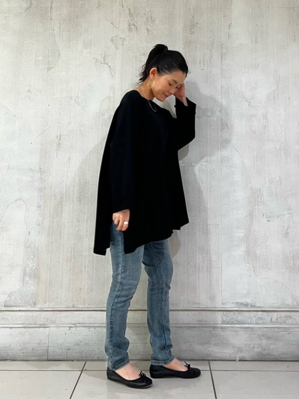 ブルー系のデニムパンツ、ブラック系のハンドバッグ、ブラック系のTシャツ/カットソーを着用したレディースの春コーディネートの4枚目の写真