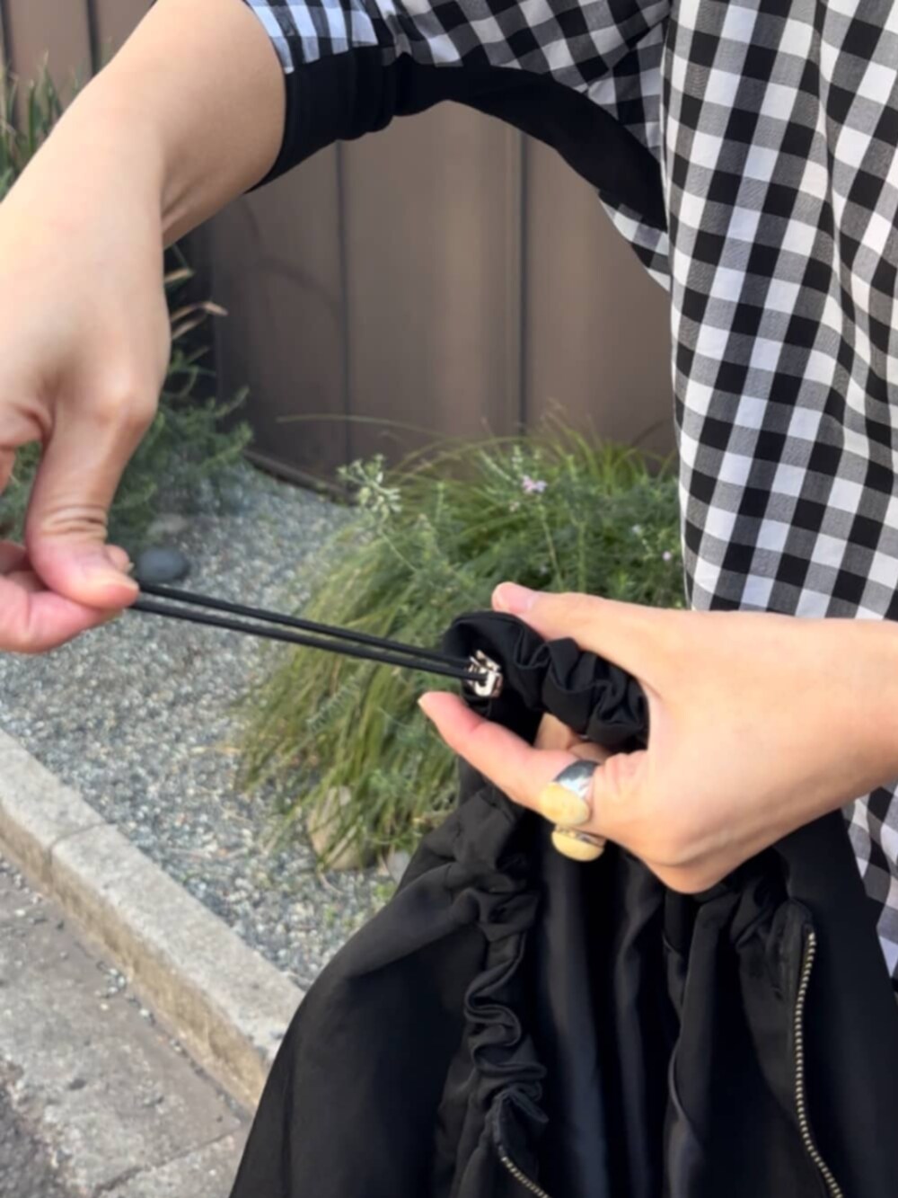 グレー系のボストンバッグ、ブラック系のノーカラージャケット、ブラック系のシャツ/ブラウスを着用したレディースの春コーディネートの9枚目の写真