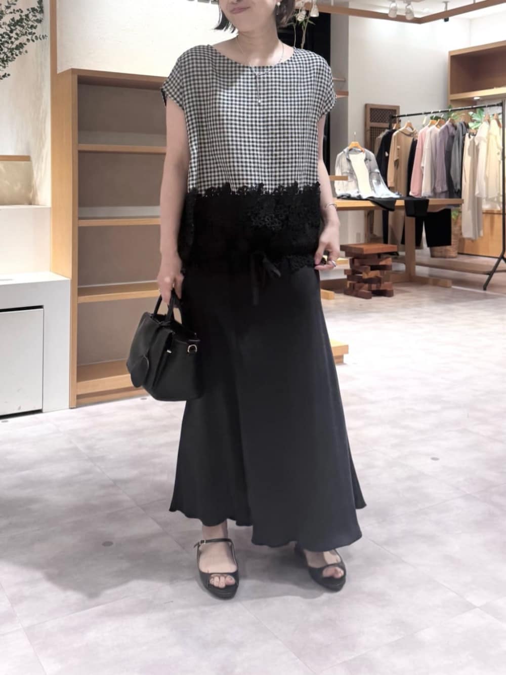 ブラック系のスカート、ブラック系のハンドバッグ、ブラック系のシャツ/ブラウスを着用したレディースの春コーディネートの5枚目の写真