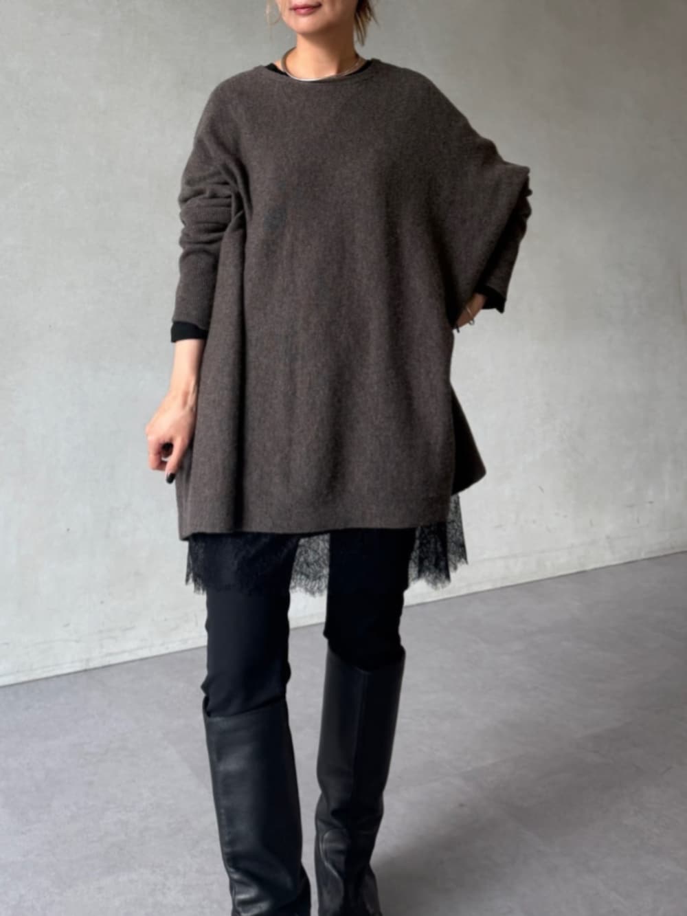 グレー系のトートバッグ、ブラウン系のニット/セーター、ブラック系のTシャツ/カットソーを着用したレディースの秋コーディネートの4枚目の写真