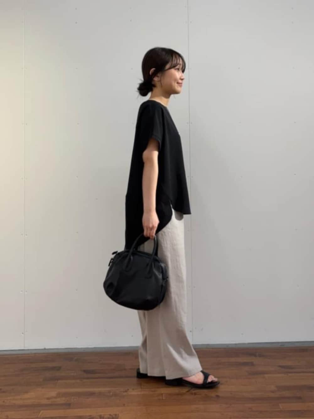 ブラック系のボストンバッグ、ブラック系のシャツ/ブラウス、グレー系のその他パンツを着用したレディースの春コーディネートの5枚目の写真