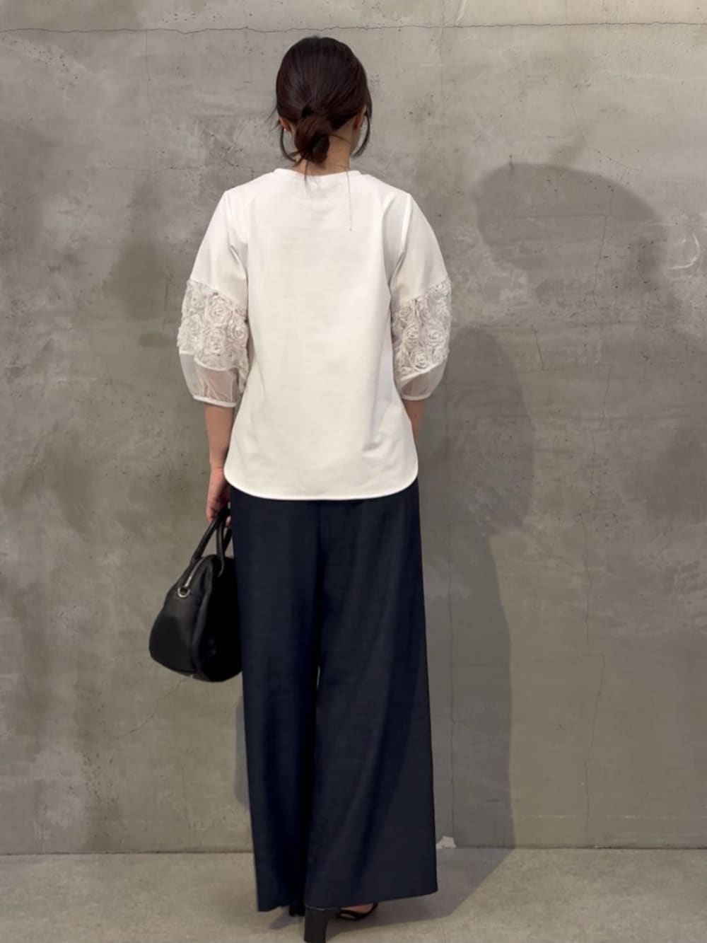 ブルー系のその他パンツ、ブラック系のボストンバッグ、ホワイト系のTシャツ/カットソーを着用したレディースの春コーディネートの3枚目の写真