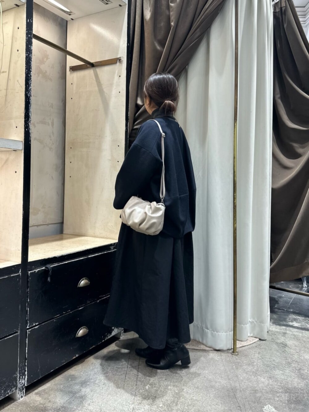 グレー系のワンピース、ブルー系のノーカラーコートを着用したレディースの冬コーディネートの4枚目の写真