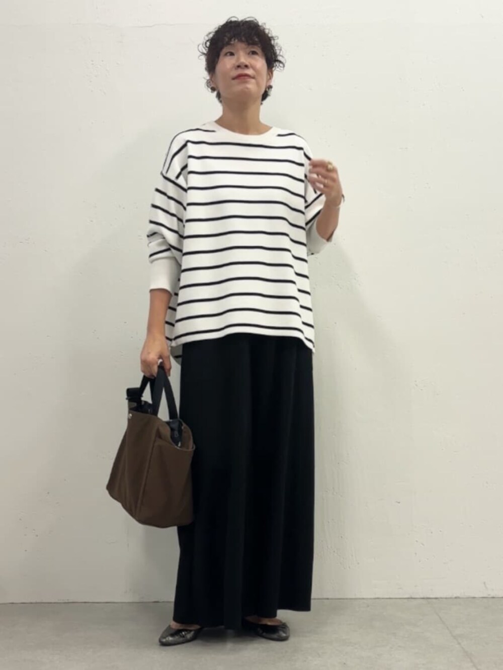 ホワイト系のノーカラージャケット、ブラック系のその他パンツ、ホワイト系のニット/セーターを着用したレディースの冬コーディネートの8枚目の写真