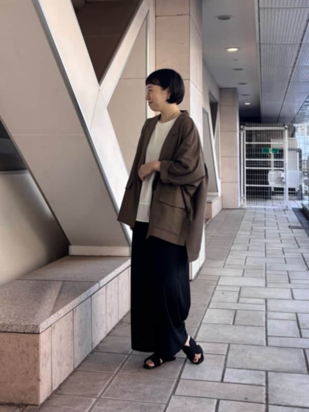 ブラック系のその他パンツ、ブラウン系のテーラードジャケット、ホワイト系のTシャツ/カットソーを着用したレディースの春コーディネートの4枚目の写真