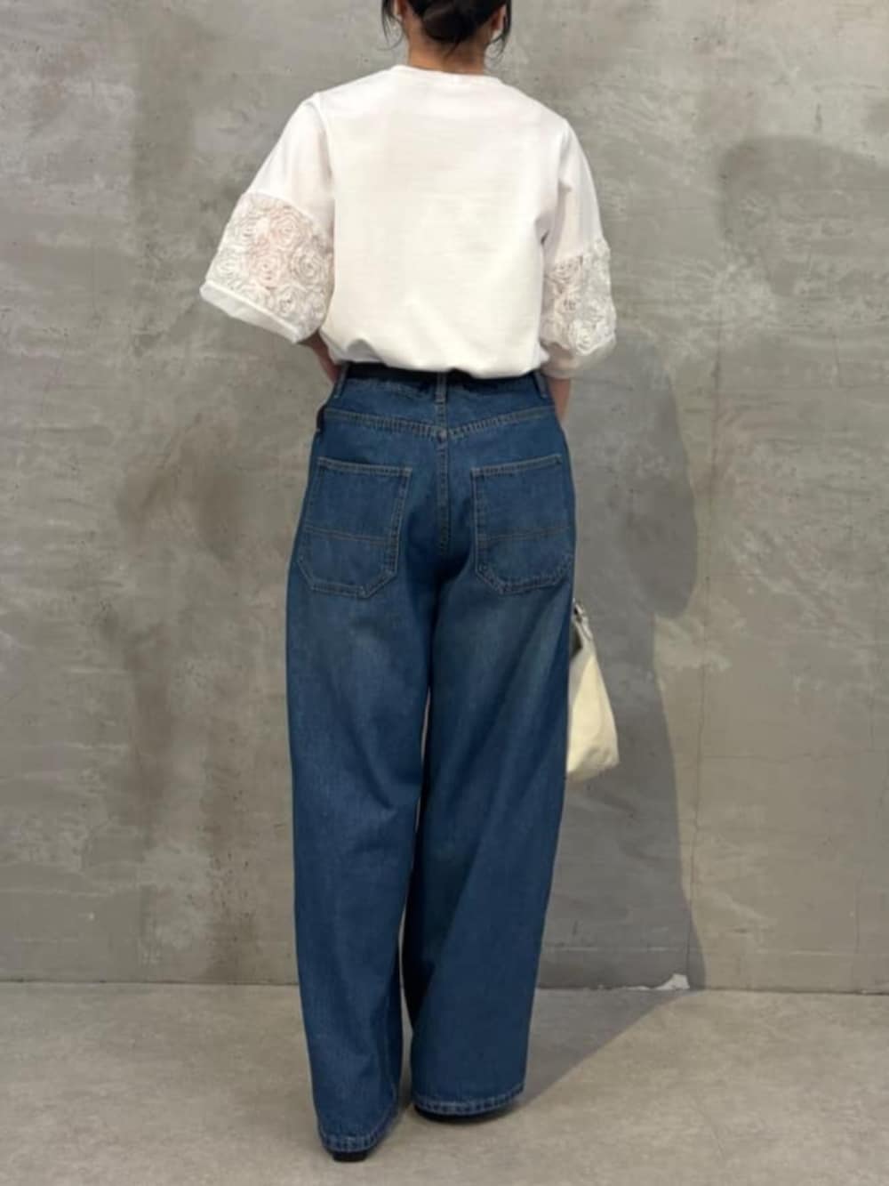 ホワイト系のトートバッグ、ブルー系のその他パンツ、ホワイト系のTシャツ/カットソーを着用したレディースの春コーディネートの4枚目の写真