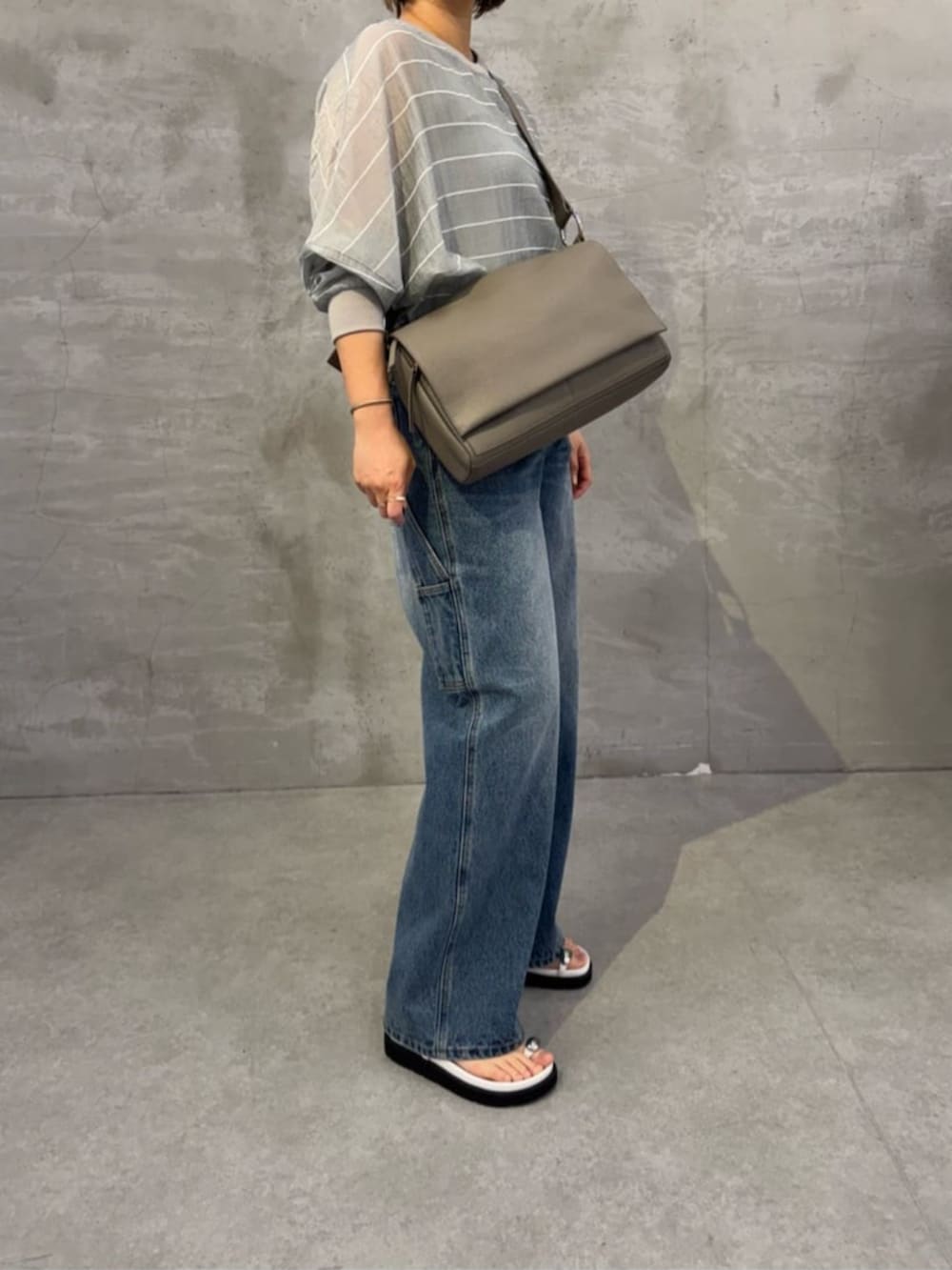 ブルー系のその他パンツ、ホワイト系のサンダル、グレー系のシャツ/ブラウスを着用したレディースの春コーディネートの6枚目の写真