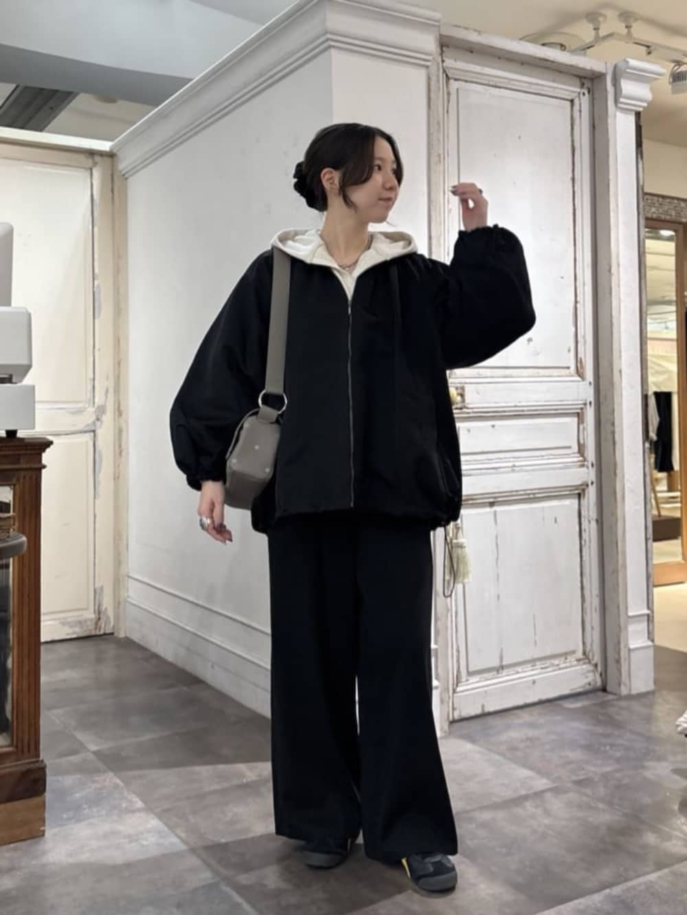 ブラック系のその他パンツ、ホワイト系のパーカー、グレー系のショルダーバッグを着用したレディースの冬コーディネートの2枚目の写真