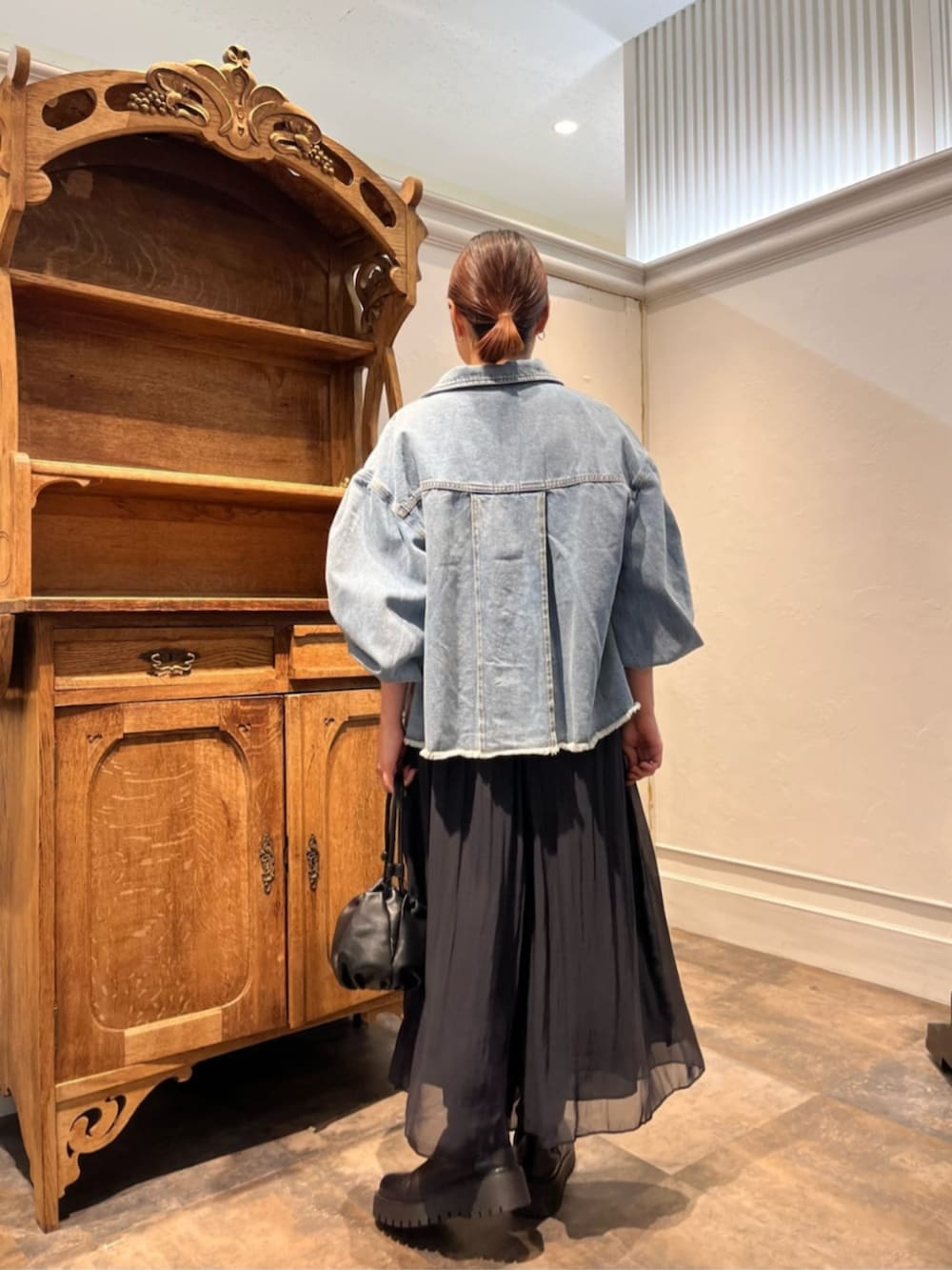 ブルー系のデニムジャケット、ブラック系のその他パンツを着用したレディースの冬コーディネートの4枚目の写真