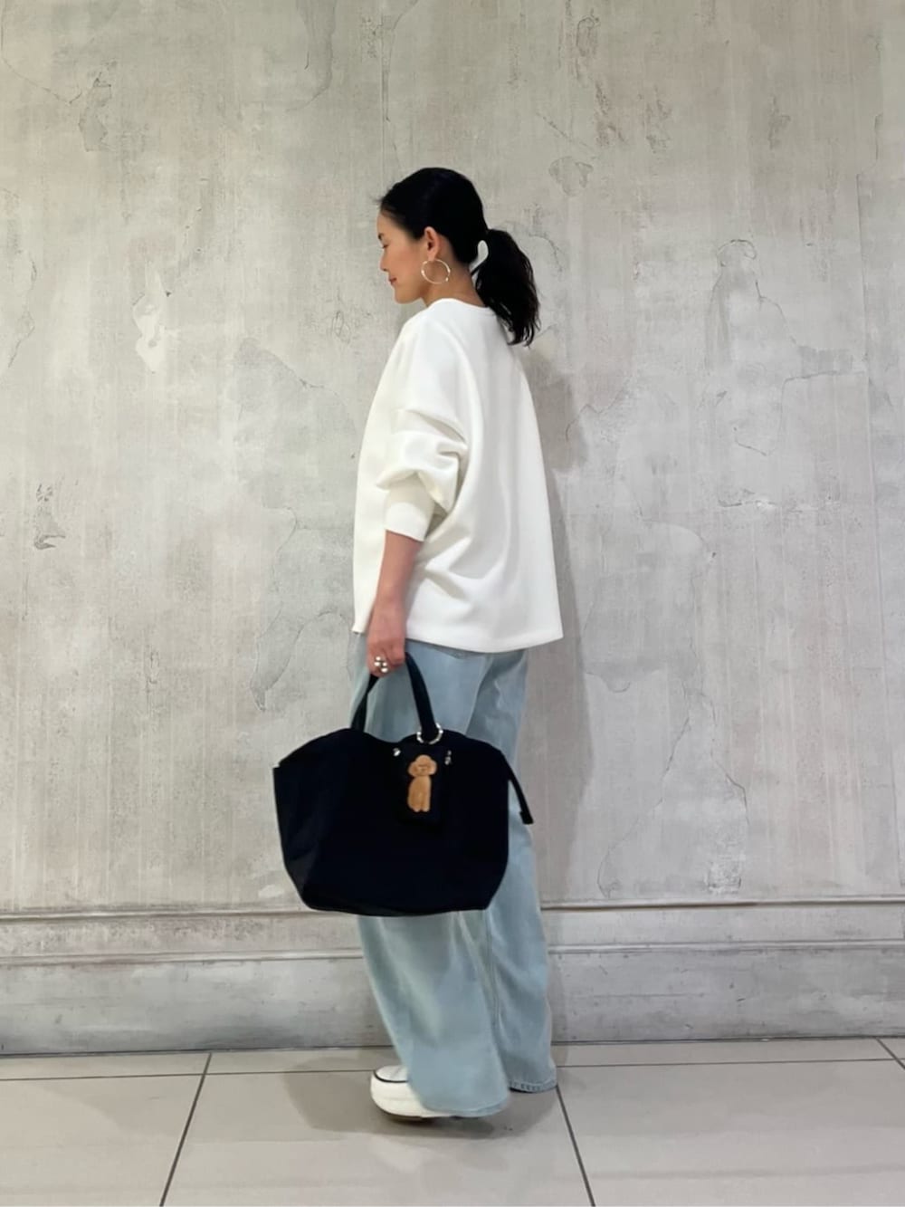 ブラック系のトートバッグ、ブラウン系のポーチを着用したレディースの冬コーディネートの3枚目の写真