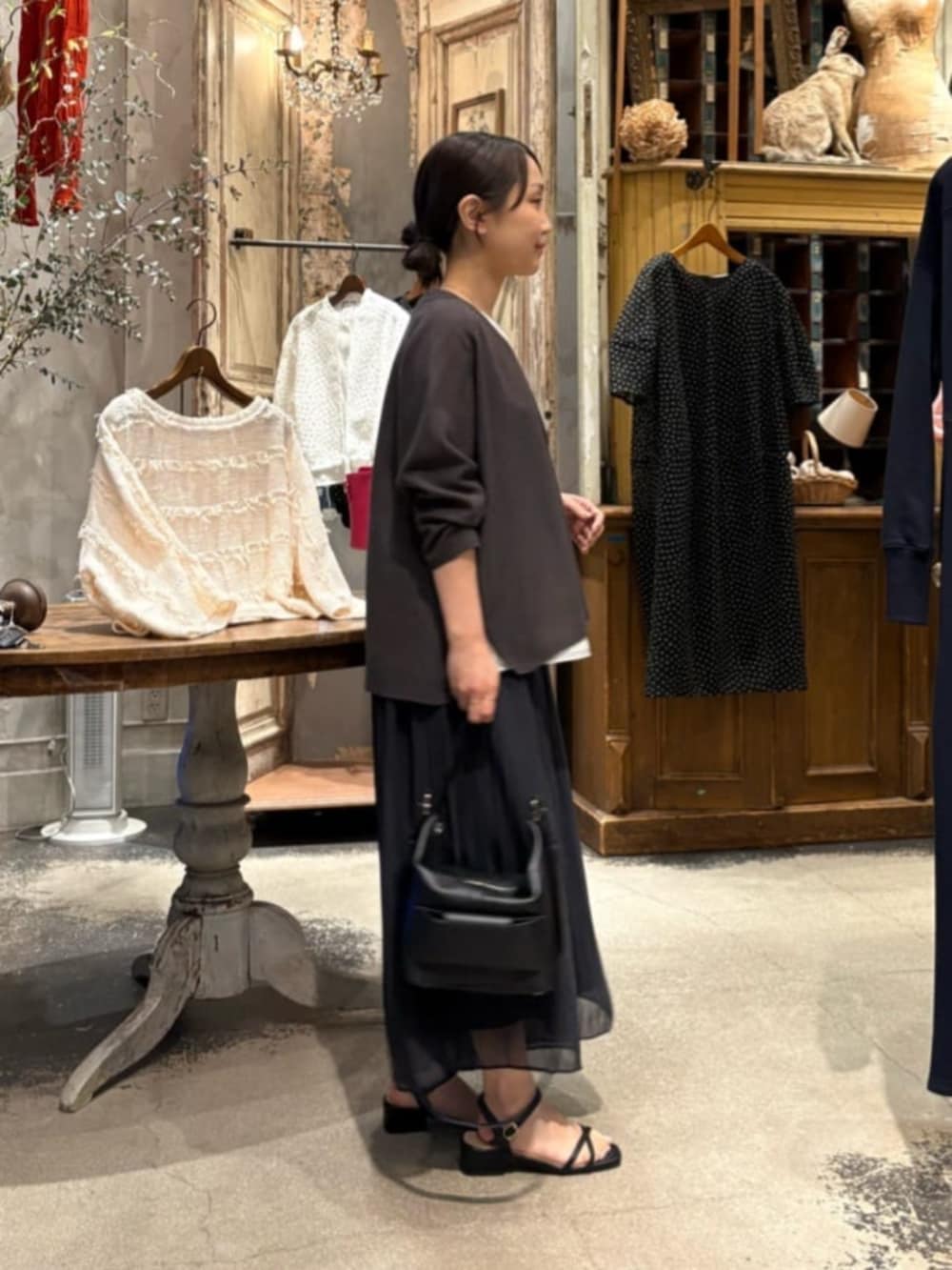 ブラック系のその他パンツ、ホワイト系のシャツ/ブラウス、グレー系のカーディガン/ボレロを着用したレディースの春コーディネートの6枚目の写真